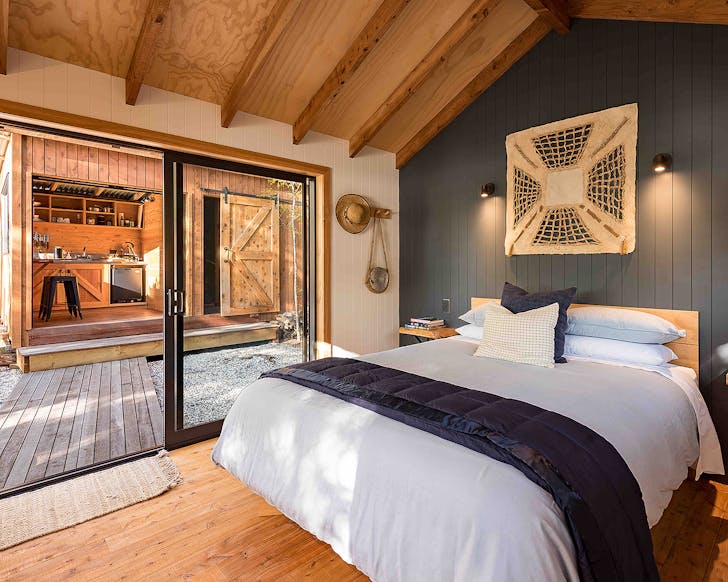 A bed in a well appointed and warm looking room.