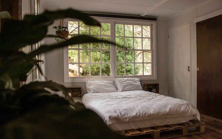 The cosy bedroom with white-linen bed of a best accomodation in Dandenong Ranges.