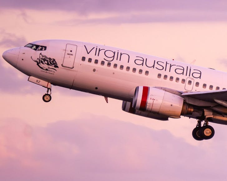 A Virgin Australia plane taking off at sunset