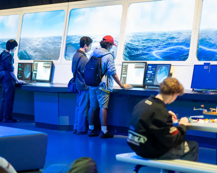 Family looking at interactive boat screen