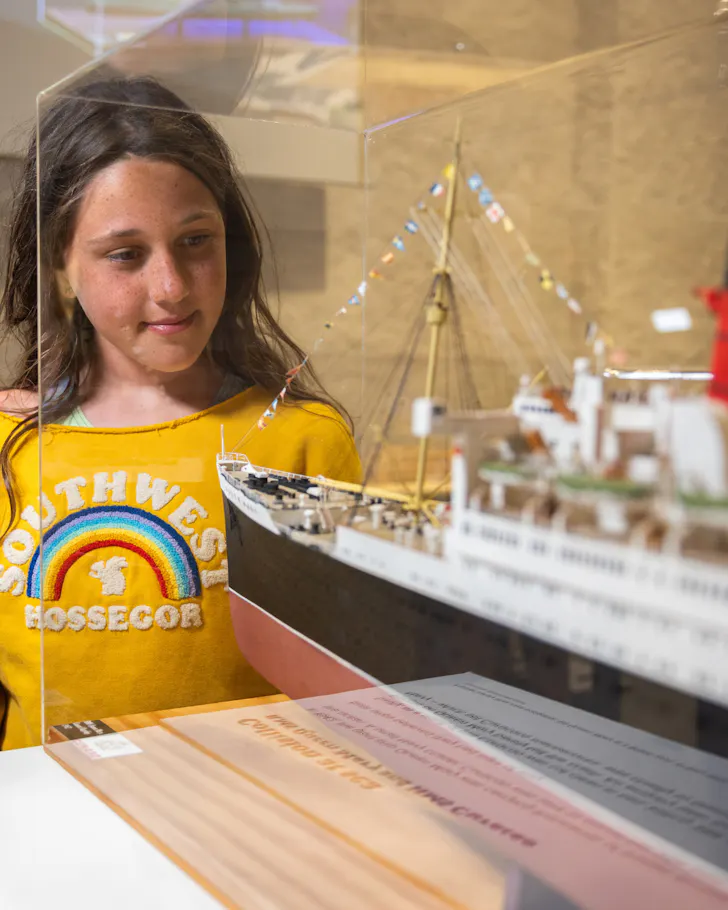 Kid staring at small boat