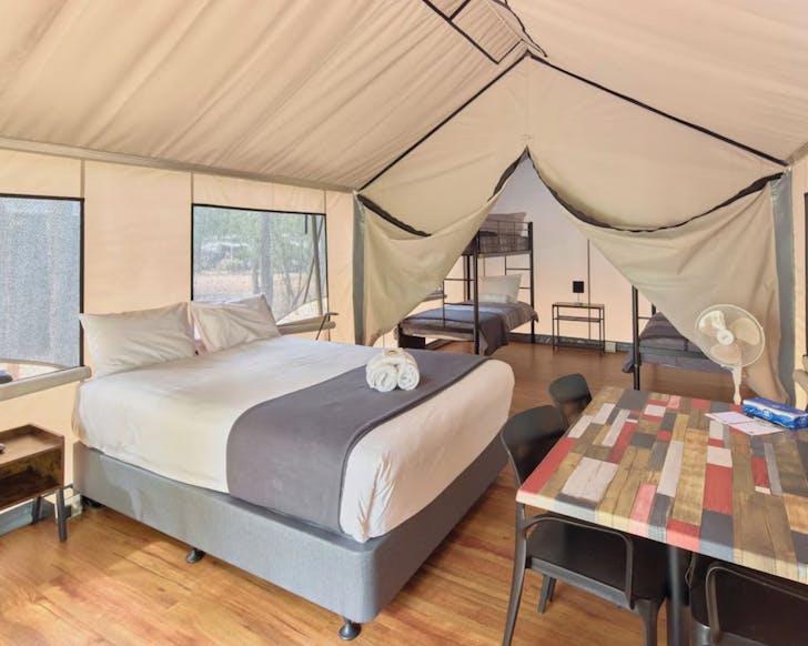 Tent with a bed and chairs in it