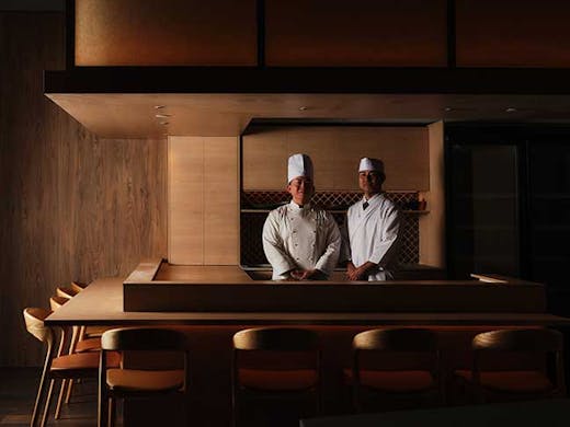 Two chefs smiling at camera aat teppanyaki grill at Wagu Ya Teppenyaki