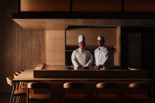 Two chefs smiling at camera aat teppanyaki grill at Wagu Ya Teppenyaki