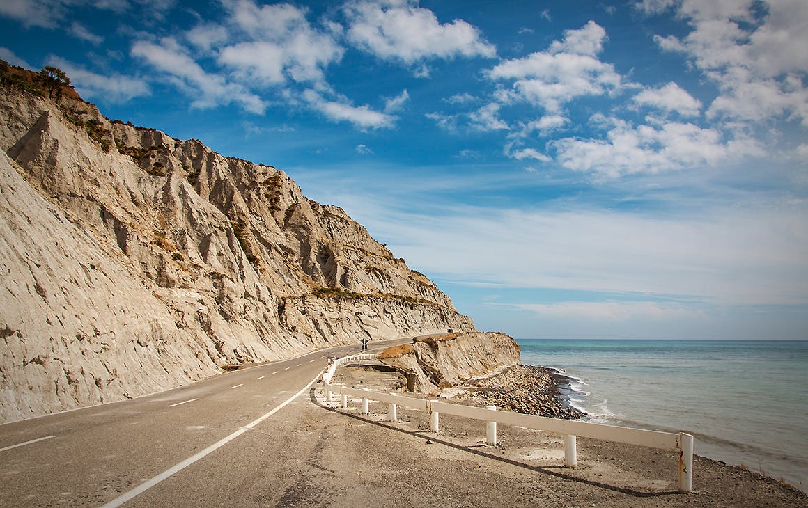 Road through eroded limestone coastal cliff at Palliser Bay, Wairarapa