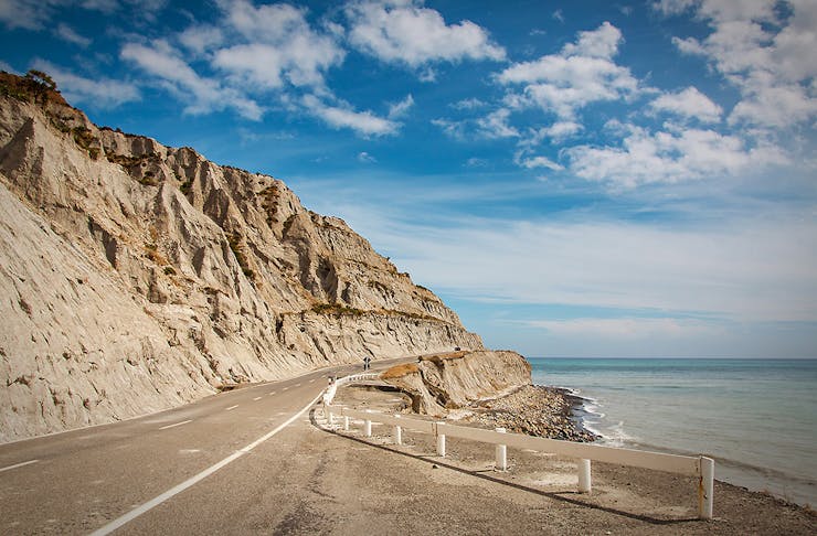 Road through eroded limestone coastal cliff at Palliser Bay, Wairarapa