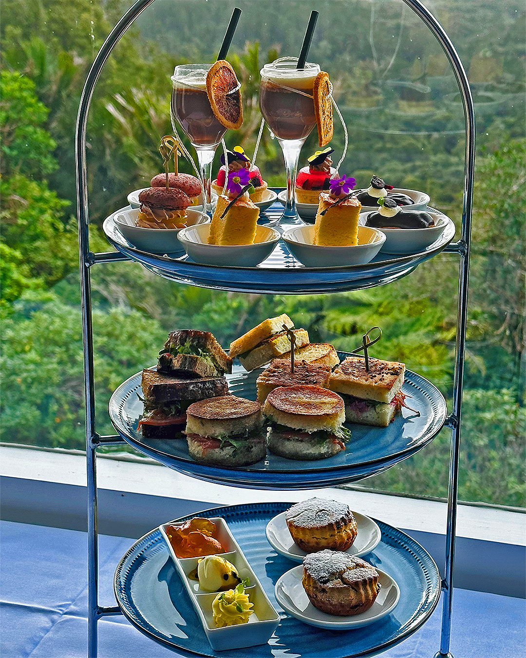 Delicate high tea fancies sit on tiers overlooking a great view at Waitakere Resort and Spa.
