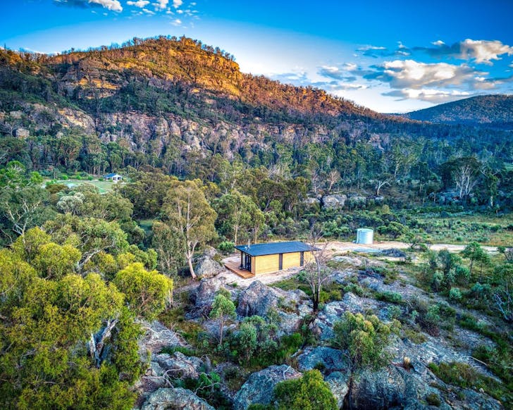 A view of Wambal Cabin nature Airbnb NSW with mountains behind it