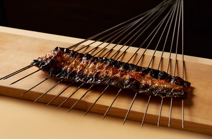 A piece of delicately grilled meat with 15 thin skewers through it at one of the best Japanese restaurants Melbourne has to offer in 2024