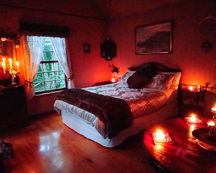 A well-appointed room is lit by candlelight.