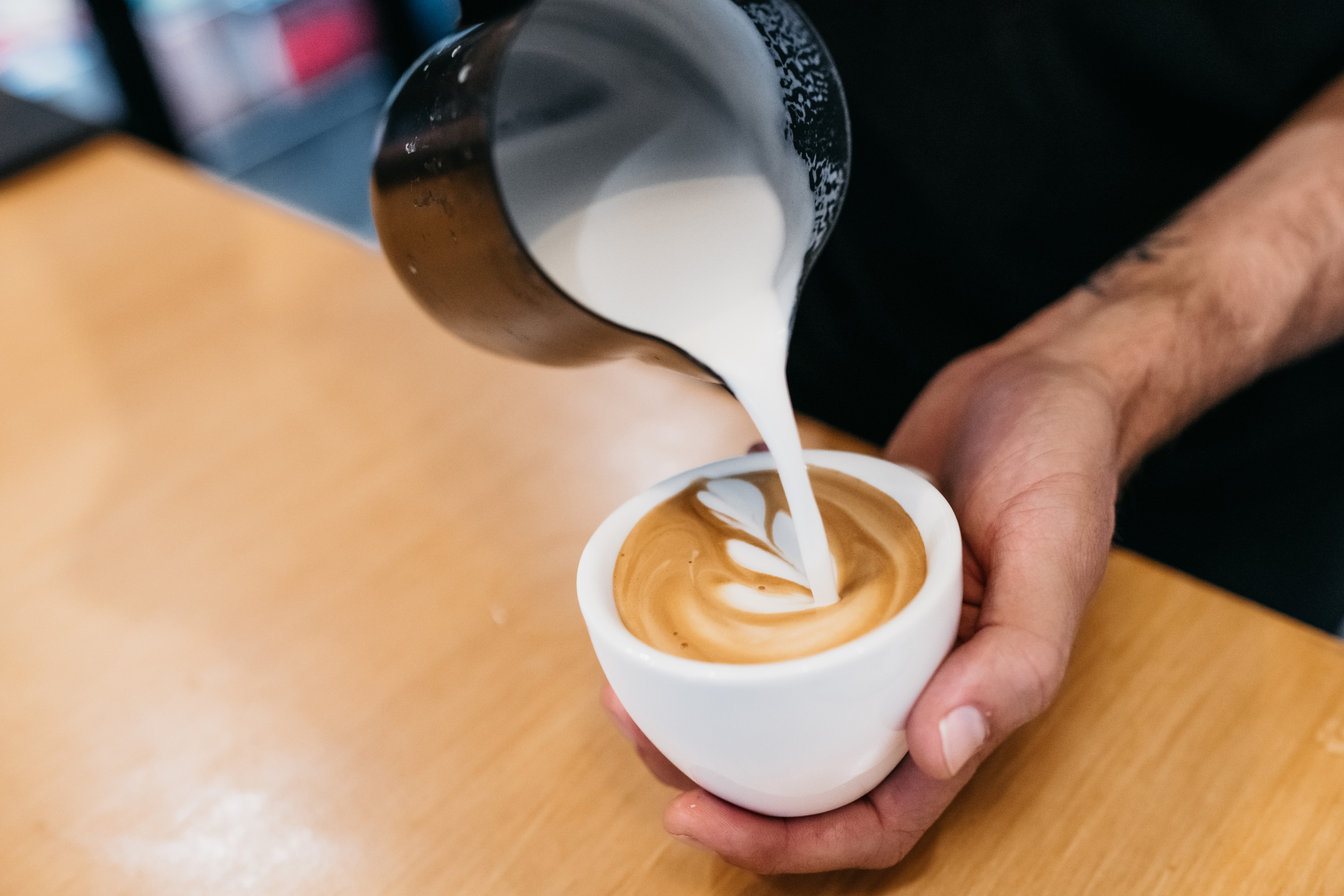 a close up shot of a person pouring coffee in a cup