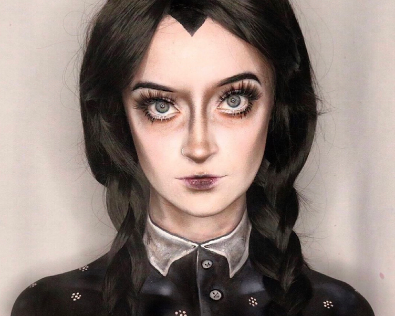 Makeup FX artist Lauren Ward wears a black wig and gothic-inspired makeup dressed in a Wednesday Addams Halloween costume. 