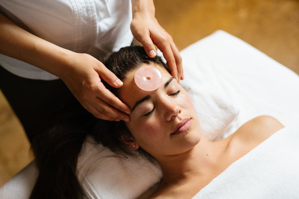 A lady gets a facial with a rose quartz stone