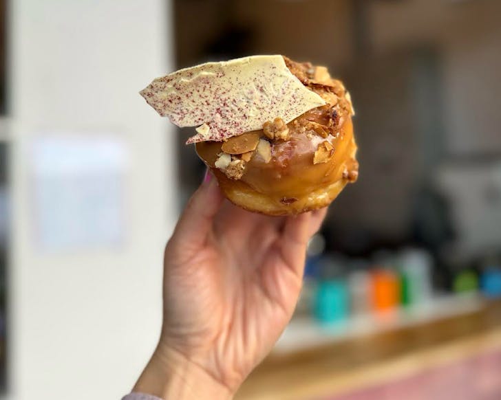 A caramel glazed doughnut with a dramatic giant white chocolate chard topping. 