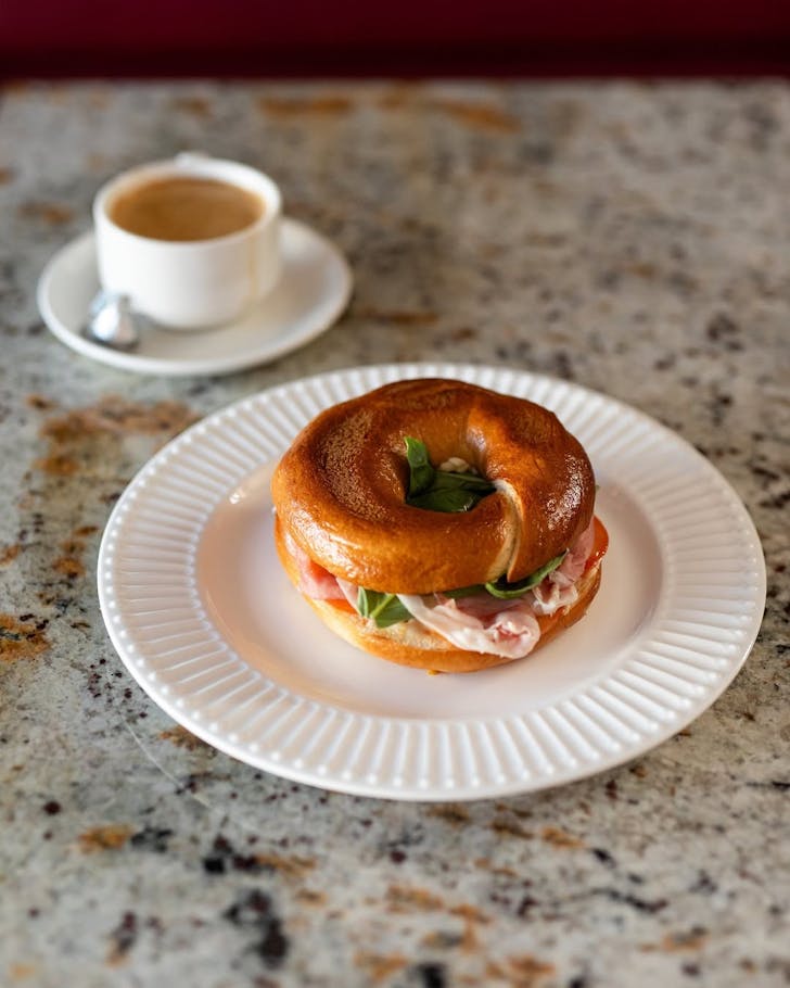 Bagel and coffee on table.