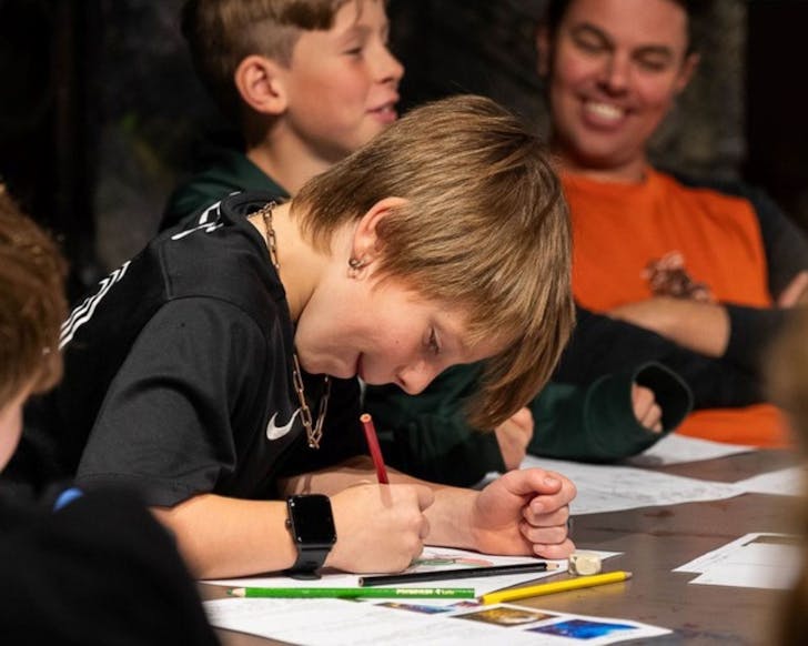 A child designs their leather craft in a Weta Workshop class