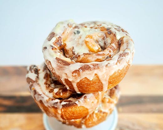 A cinnamon roll from Wildflour Matilda Bakery with a glazed sugar rolling down across it.  
