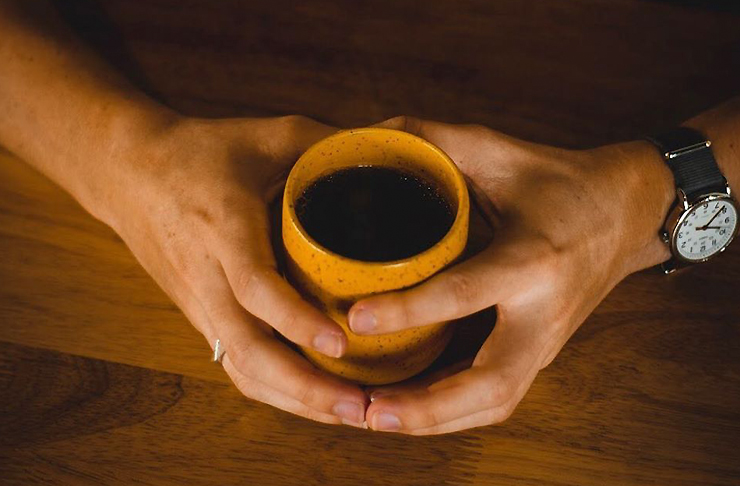 A black filter coffee in a yellow and black speckled ceramic mug