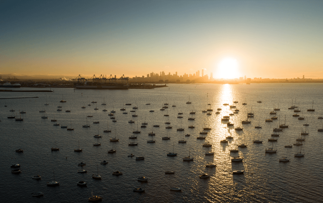 A large marina with boats overlooking the city during sunset at one of the best beaches in Melbourne.