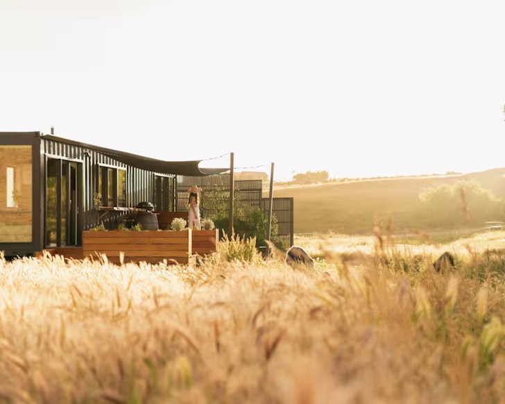 A view of Willowbrook Retreat cabin surrounded by fields in New Zealand