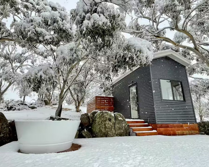 Wombat Luxury Eco Tiny Home one of the best accommodation options for couples near Jindabyne is pictured surrounded by snow