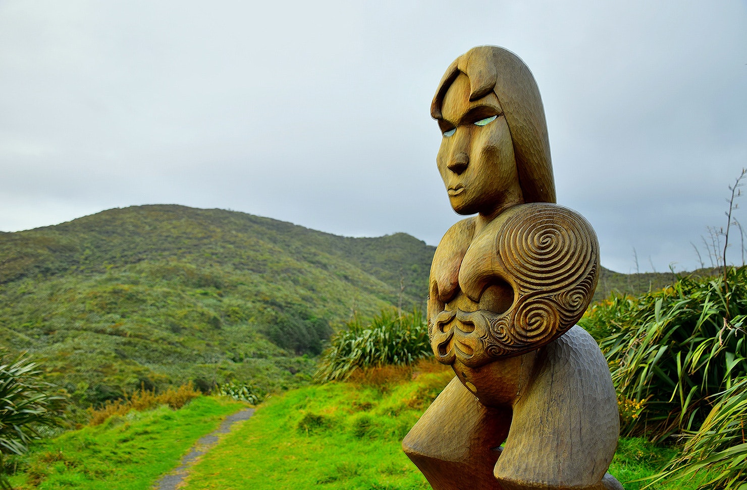 Wooden Maori carving of Hinerangi, female ancestor guardian figure at Piha, New Zealand.