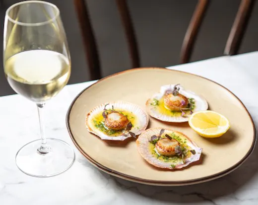 Glass of wine and a plate of scallops