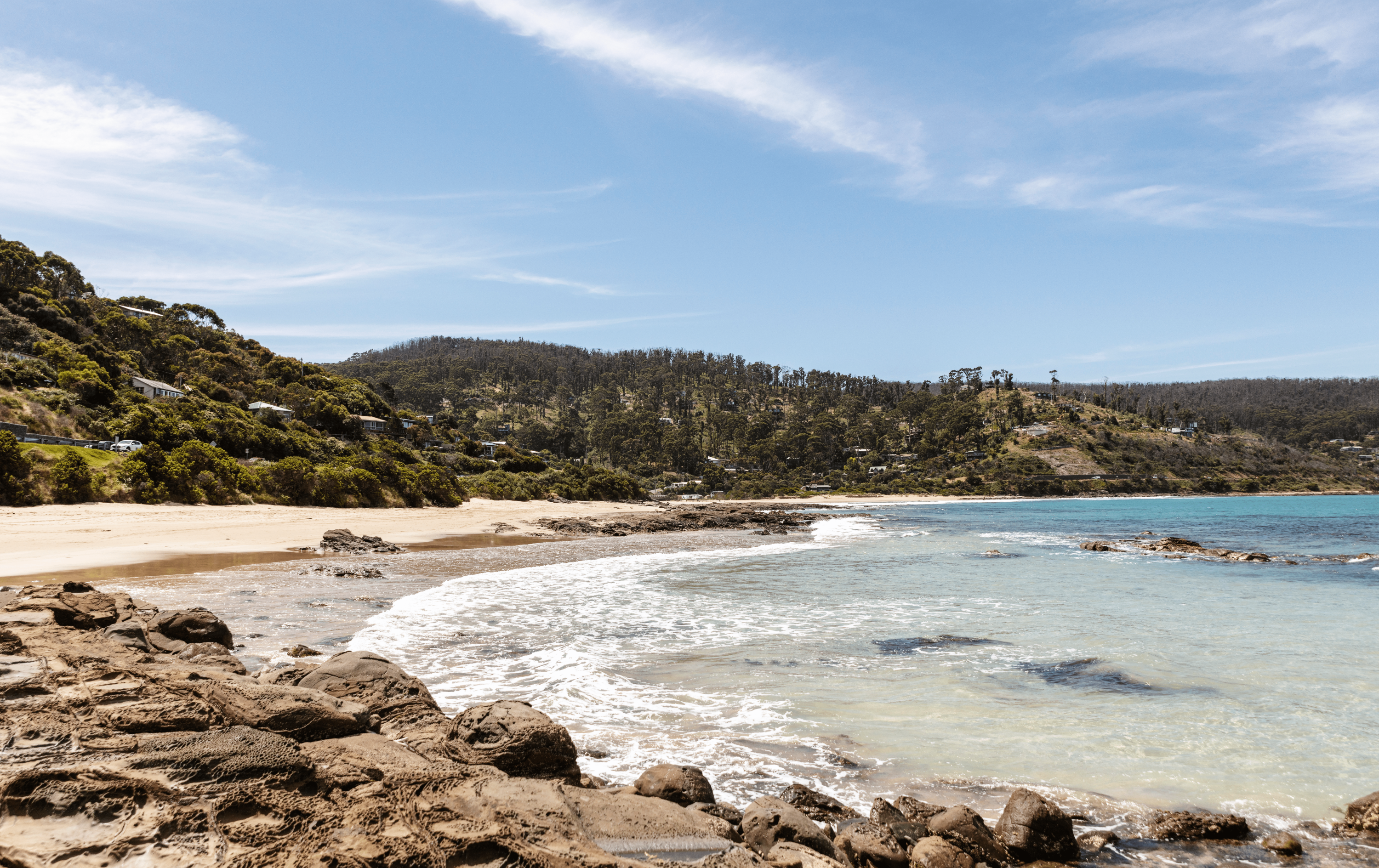 A small shore wave crashing onto sand at one of the best beaches in Victoria