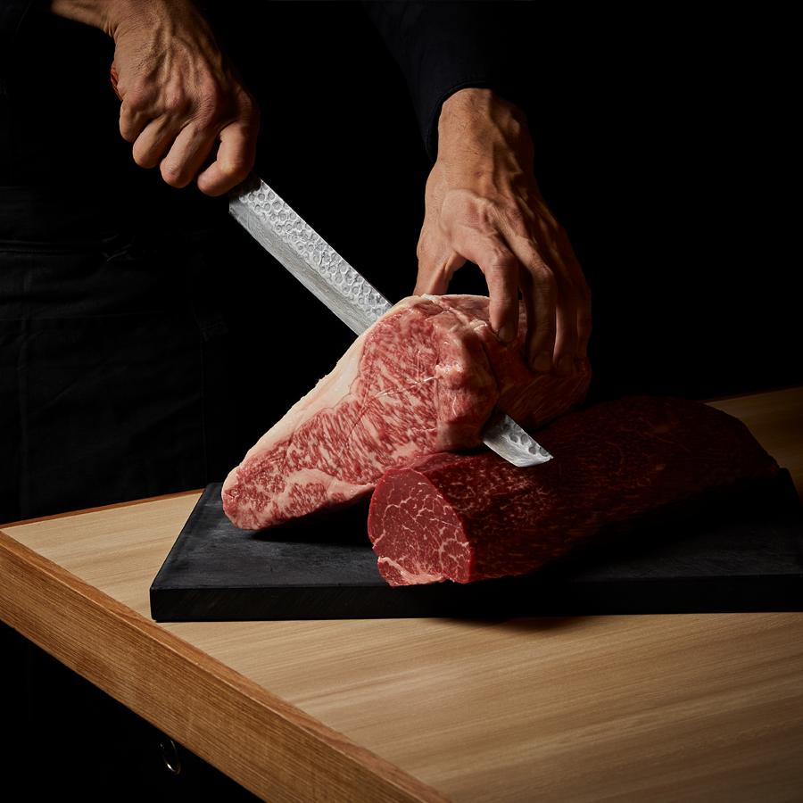 A person sliding into a marbled piece of beef, one of the best steak in Melbourne. 