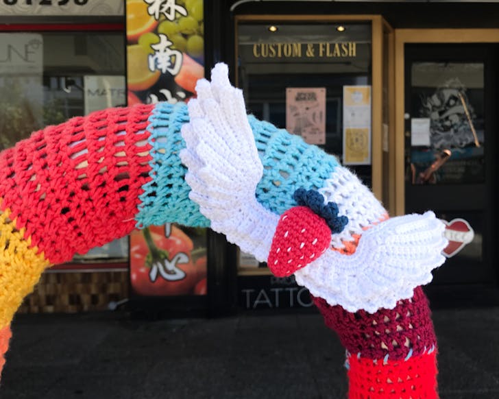 A crocheted, winged strawberry attached to a bike parking station on Karangahape Road. 