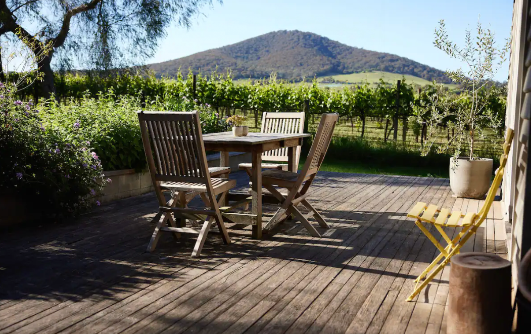 An outdoor table with a large hill behind it at one of the best airbnbs in Victoria.