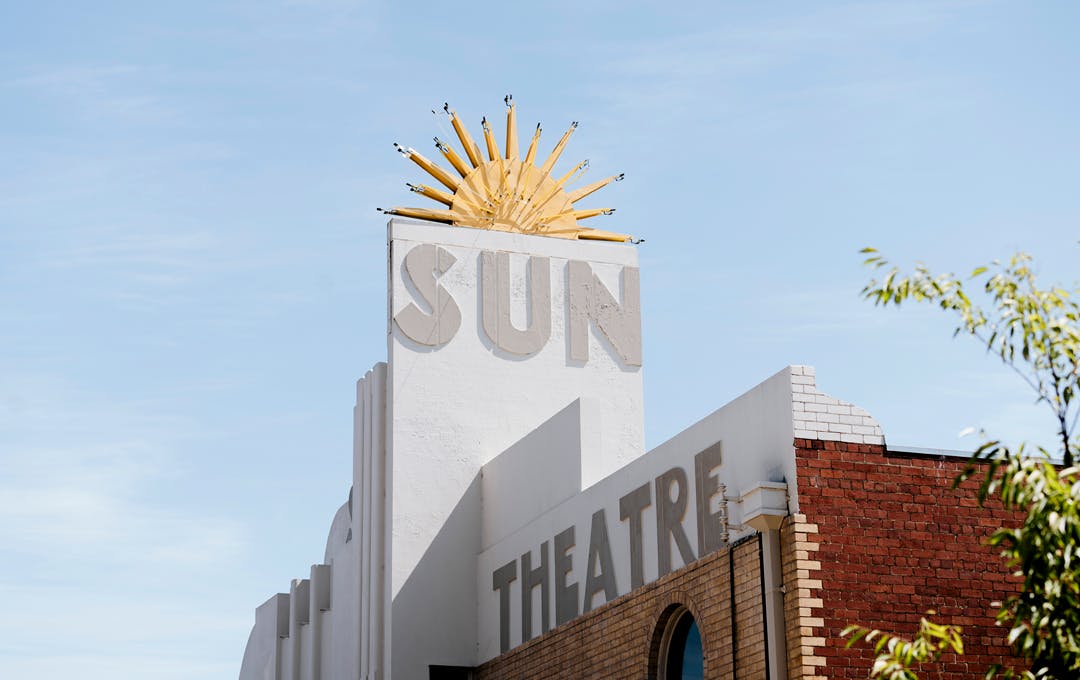 The sign of the Sun Theatre Yarraville with a large sun in the blue sky. 