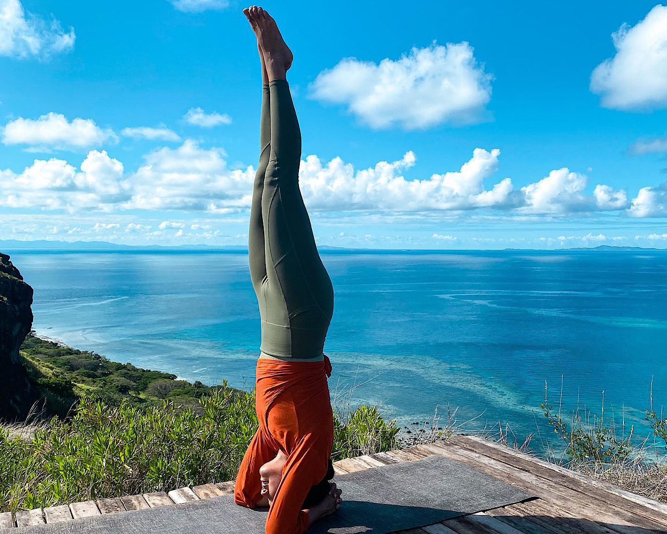 A yoga instructor balances in a tripod headstand at Vomo Island. 