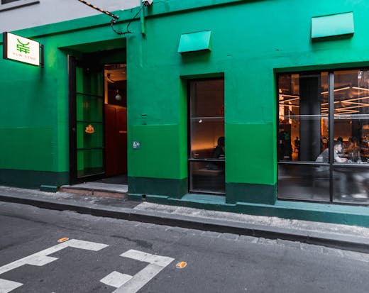 A green-painted wall of a restaurant in a CBD laneway. 