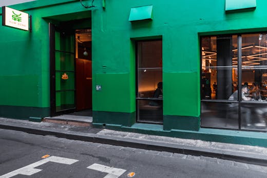 A green-painted wall of a restaurant in a CBD laneway.