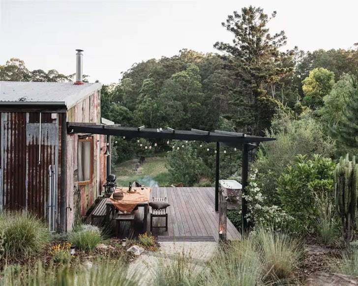 A view of the outdoor deck and bath at Yutori Cottage one of the best Noosa Airbnbs