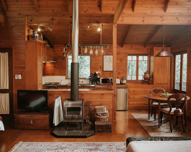 A view of the living space and fireplace at The Bower cabin, bear Brisbane