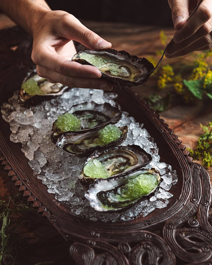 Fresh oysters served on ice and an intricately carved platter at Ahi.