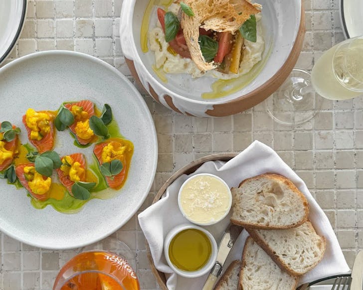 Plates of food including salmon capers and fresh bread at Bivacco.