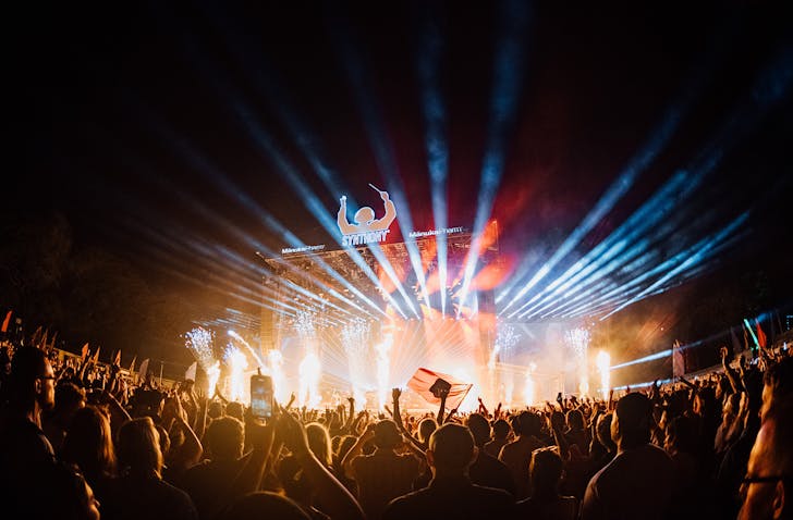 SYNTHONY plays in front of a massive audience at night with a full-light display.