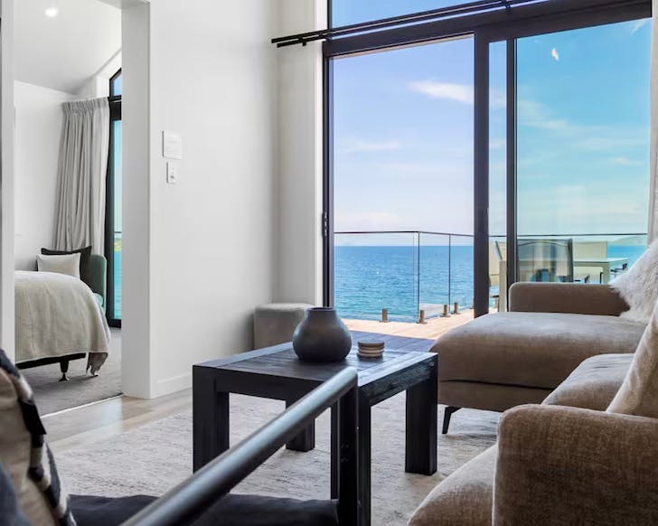 A view of a modern lounge looking straight onto a bright blue lake.