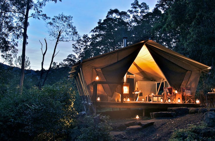 a beautiful scene at night, a glamping tent glows.