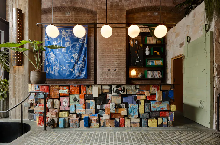 Painted bricks make up the reception desk at Ace Hotel Sydney