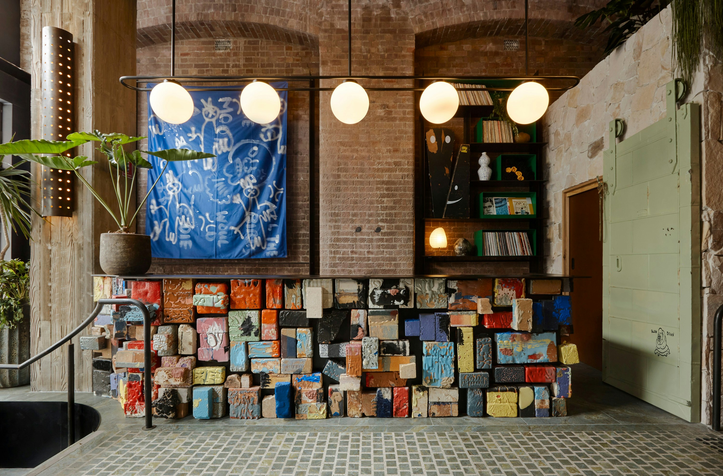 Painted bricks make up the reception desk at Ace Hotel Sydney