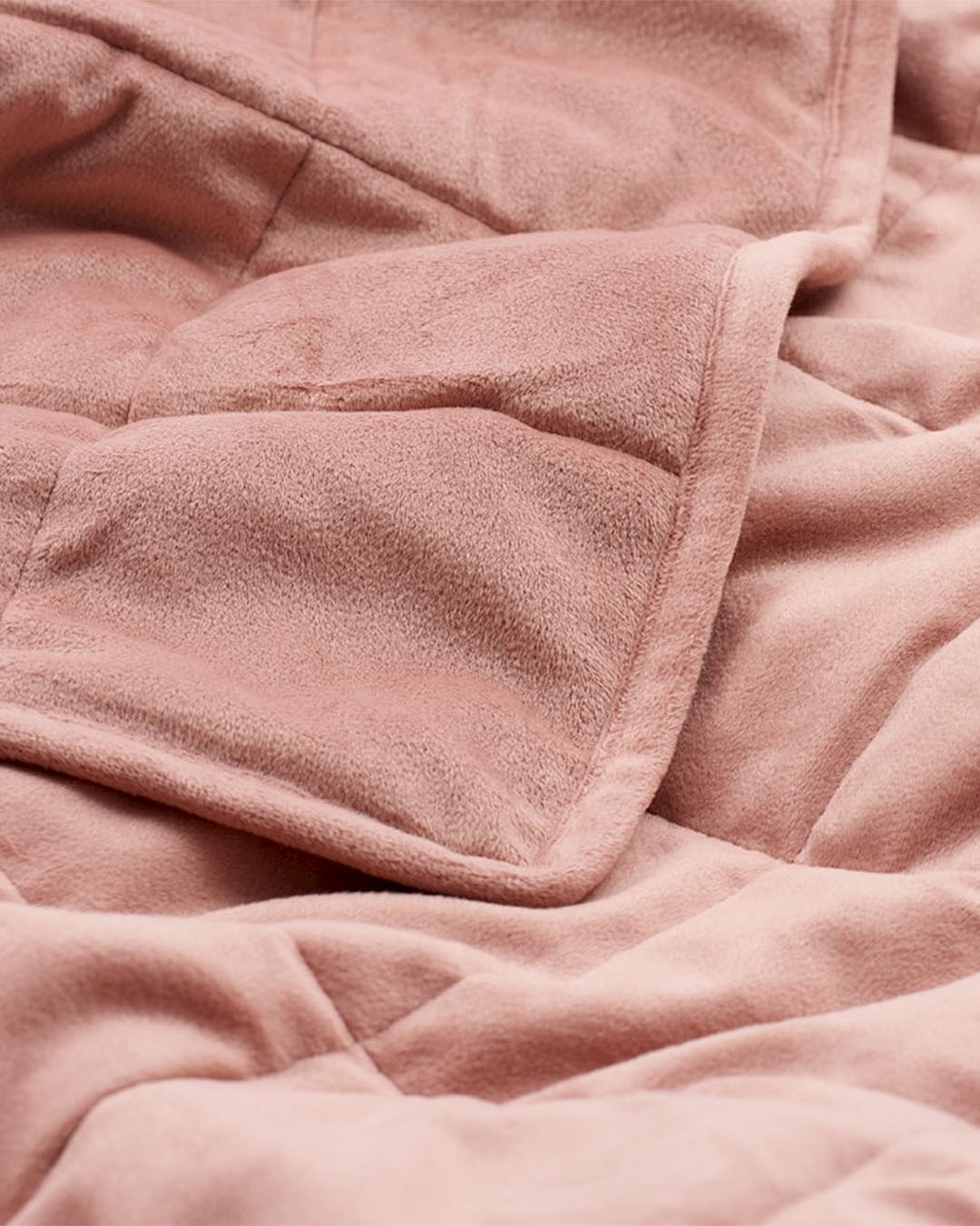 A dusty rose weighted blanket up close and personal.