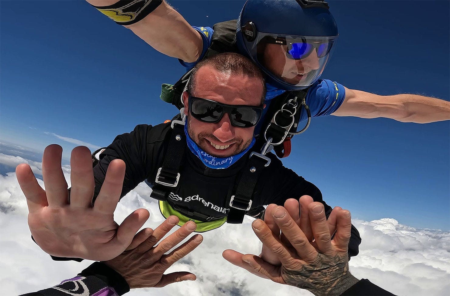 Skydivers high fiving in the sky.