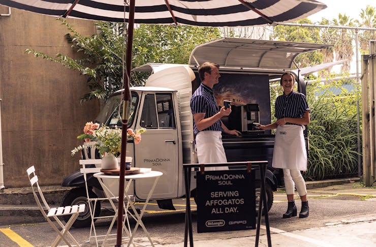 The affogato truck with two people waiting to serve you coffee.