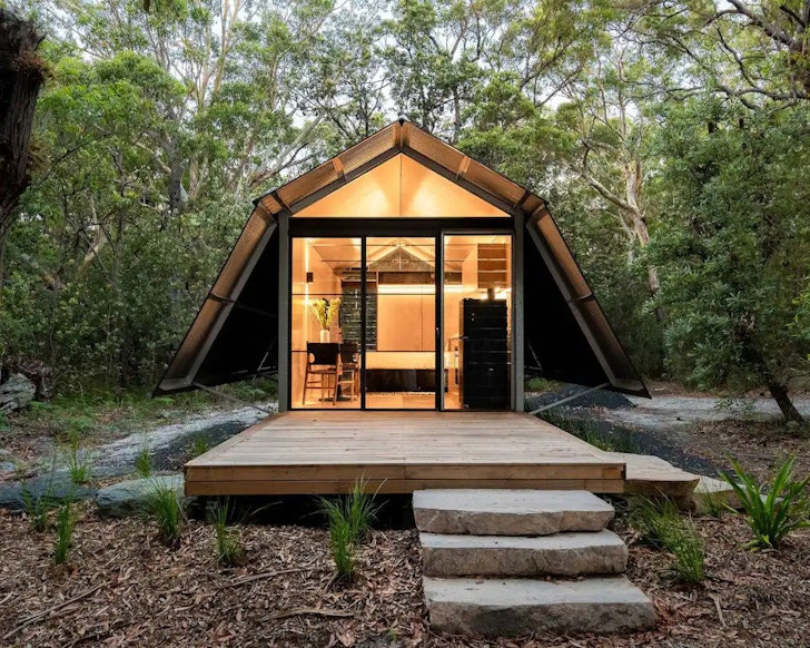 An exterior view of The Hideaway  surrounded by trees, one of the best NSW Airbnbs