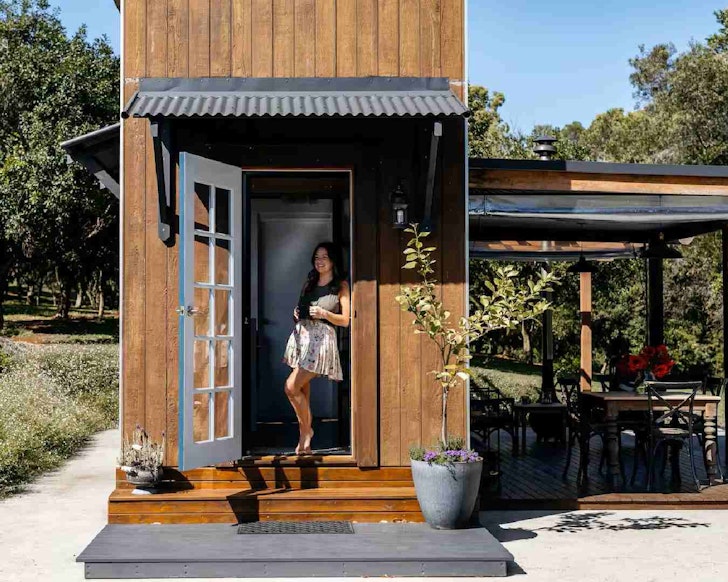 A guest stands at the door of a tiny home in South East Queensland
