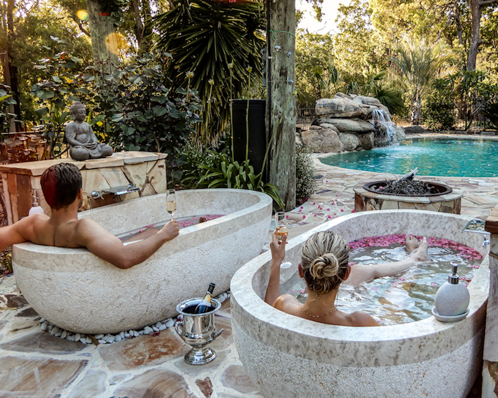 Two people in the outdoor baths at 
Kangaroo Valley Homestead one of the best kid-friendly Airbnbs Australia